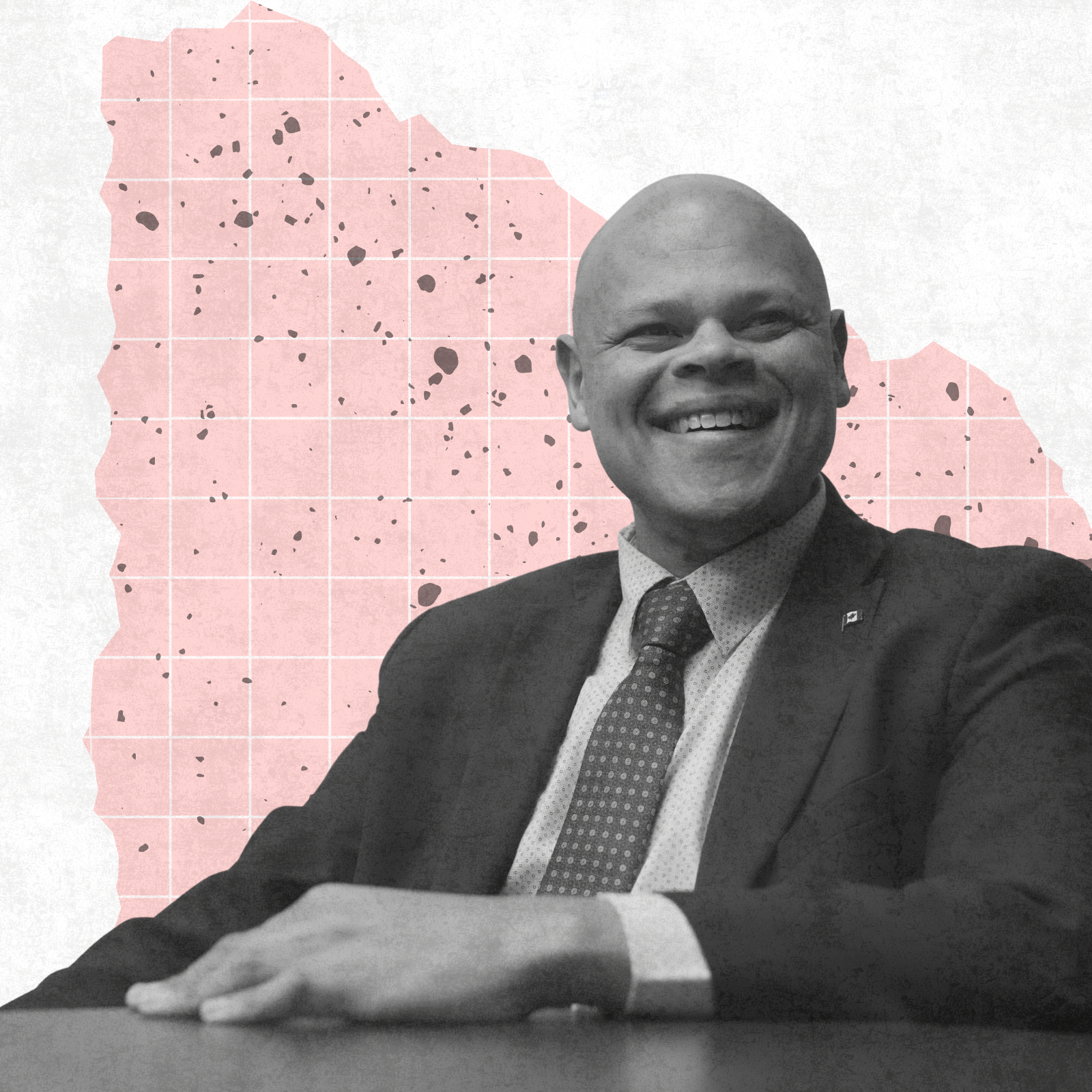 A black-and-white image of Jamil Jivani smiling while seated against an abstract pink and white background